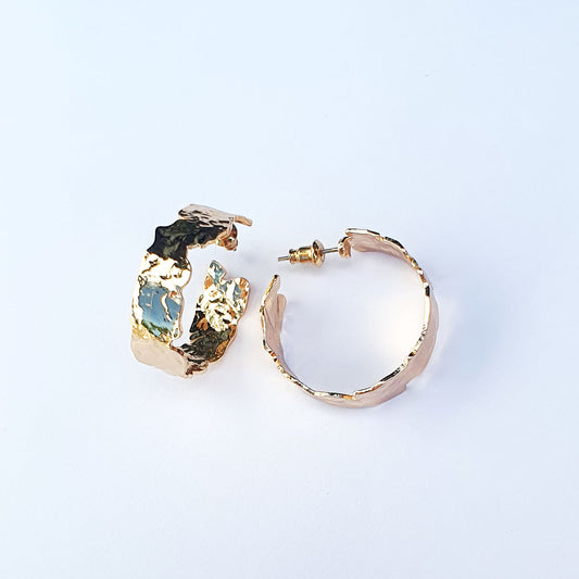 Beaten gold plated hoops of an irregular textured design.