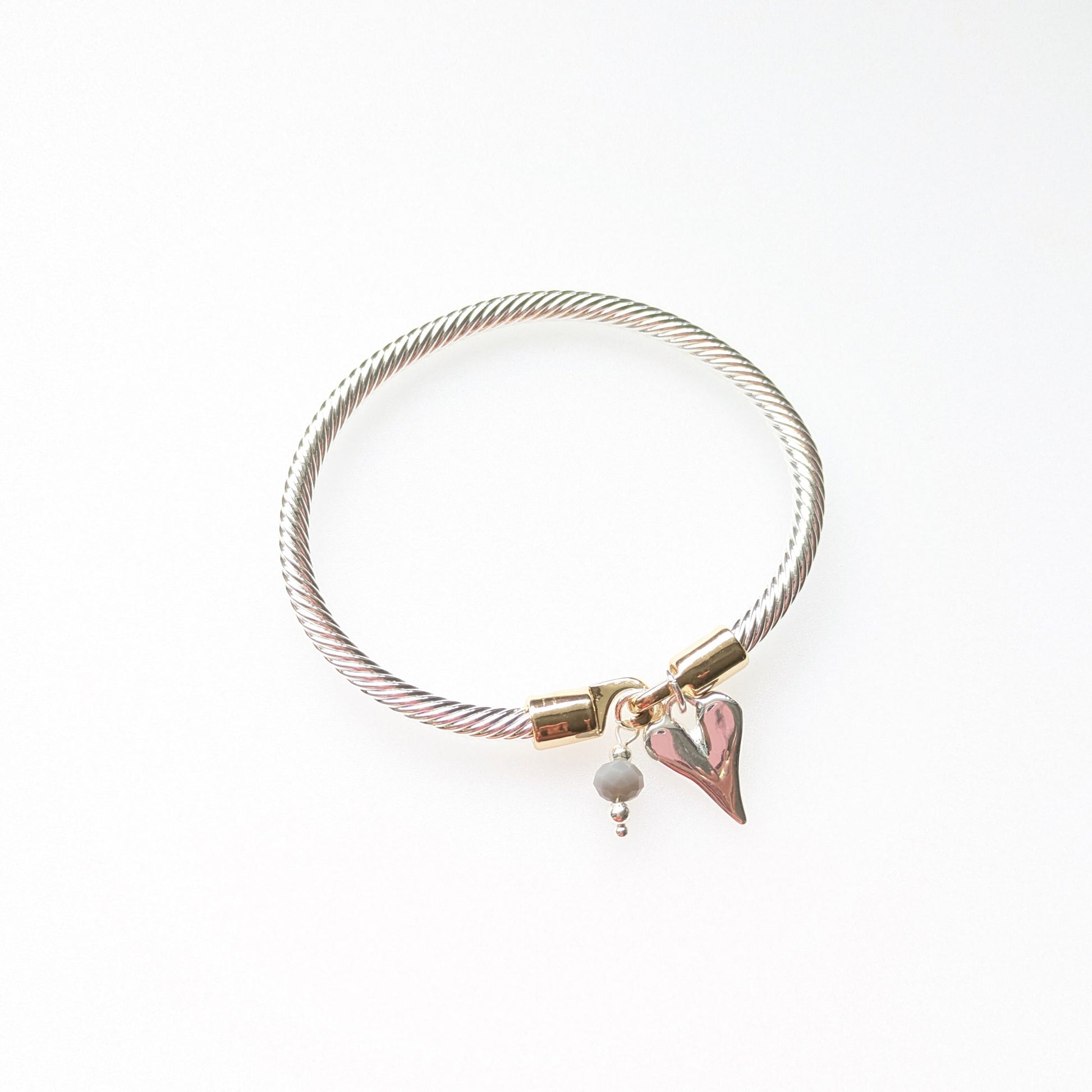 Twisted rope effect silver plated bangle with a charm on the rose gold plated clasp