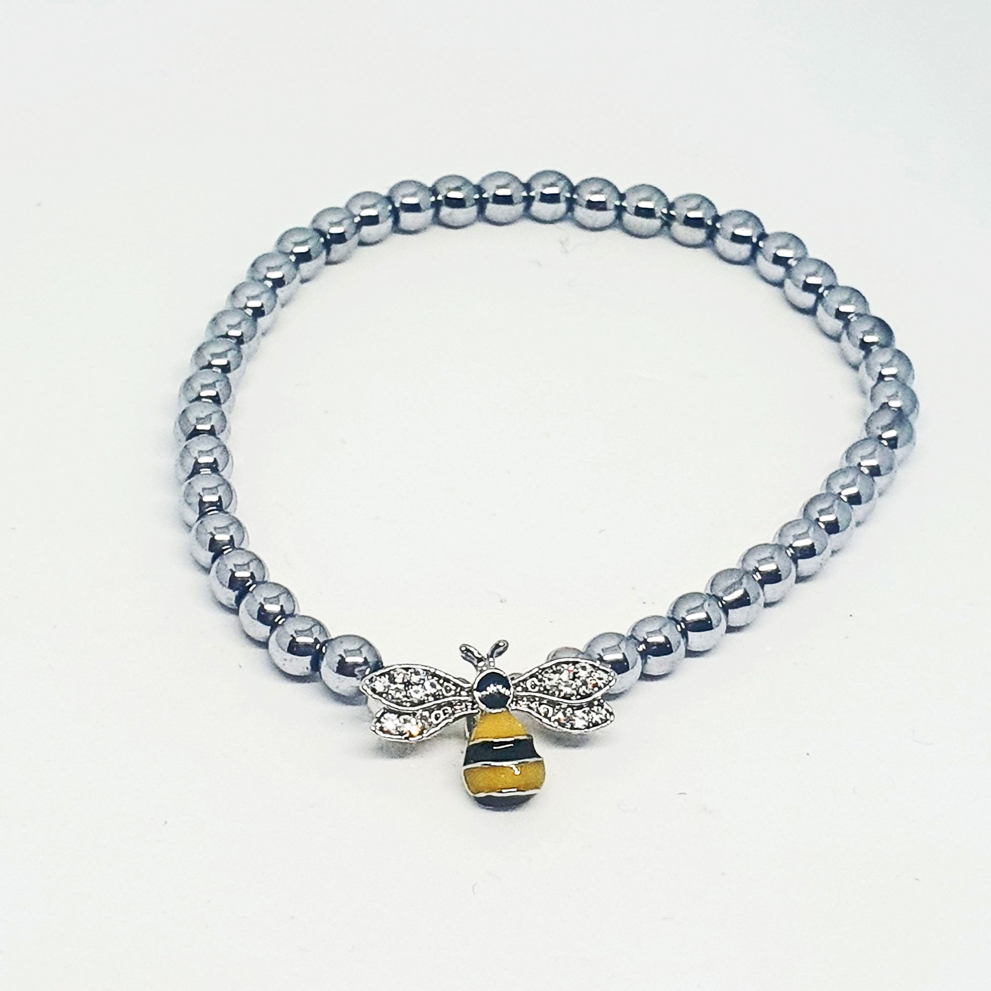 Enamel bee set on an elasticated band of hematine