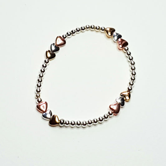 Silver and gold plated hematine hearts on an elasticated band