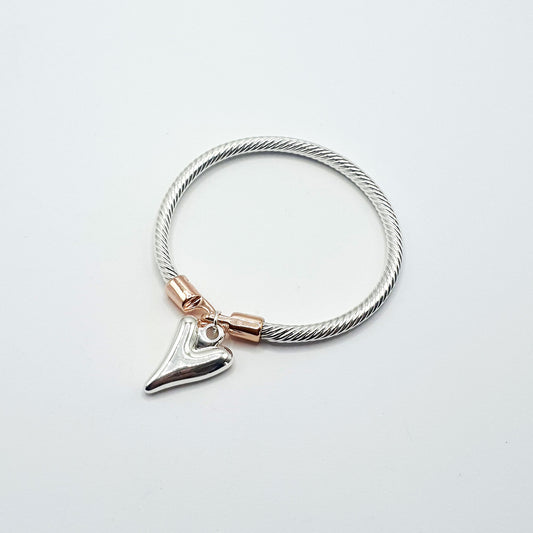 Twisted rope effect silver plated bangle with a charm on the rose gold plated clasp
